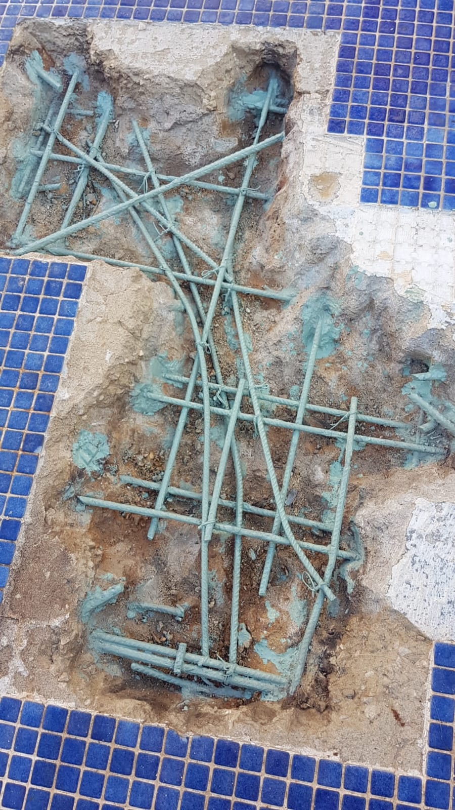 Exposed rebar grid primed with anti-corrosion compound in pool shell